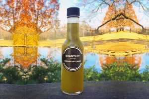 serrano hot sauce photographed outside in front of lake